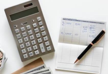 Calculator, a pen and a notebook