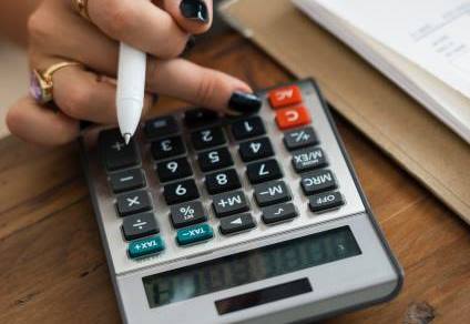 Woman holding a pen with a calculator