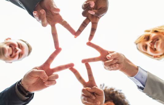 A smiling team with fingers that form a star