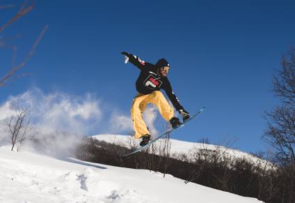 Man in Yellow Pants on a Snowboard